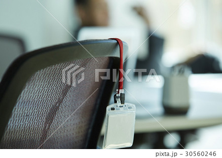 the employee ID card is hung on the chair. 30560246