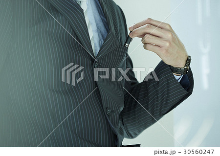 the businessman is holding the pen. 30560247