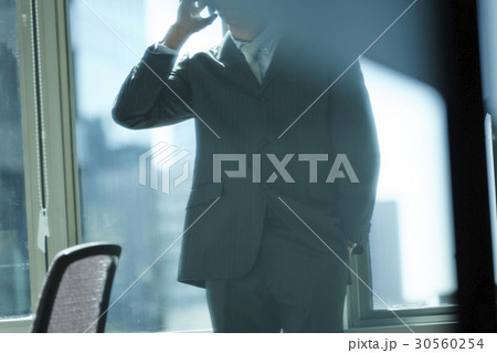 the man is standing and putting his hand in his pocket. 30560254