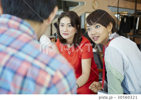 the two women are listening to their colleague. the two women are listening to their colleague. 30560321