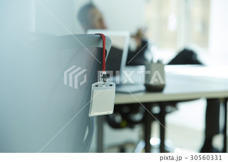 a blurry image of an employee ID card hung on a chair. 30560331