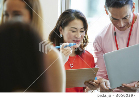 two people are discussing happily at workplace two people are discussing happily at workplace 30560397