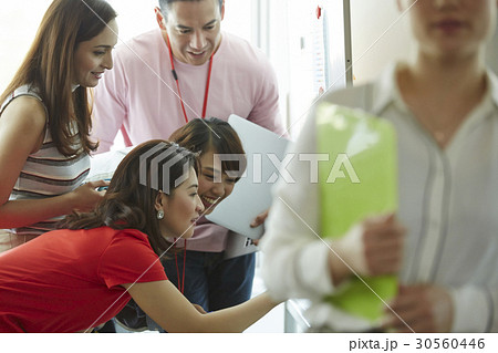 Four of five people is smiling and looking at something 30560446
