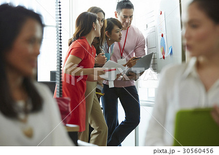 Four of six people are standing and discussing 30560456