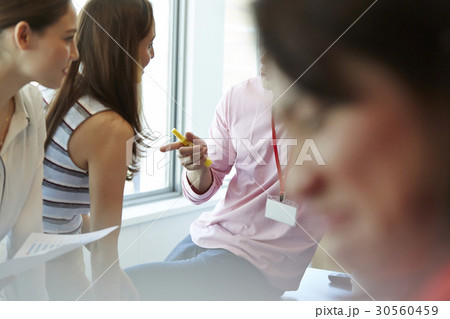 Two women are talking to a man 30560459