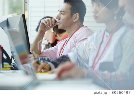 A portrait of a man looking and thinking next to colleagues A portrait of a man looking and thinking next to colleagues 30560497