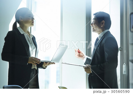 Two business people are talking and discussing in the office. Two business people are talking and discussing in the office. 30560590