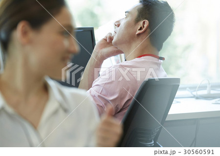 A businessman is talking on phone at work A businessman is talking on phone at work 30560591