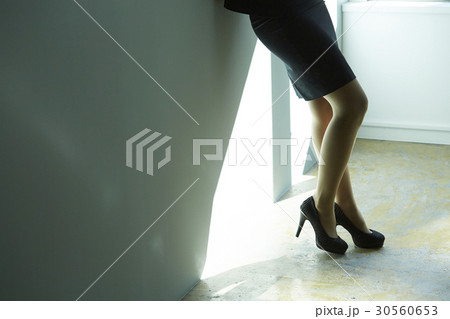 Low parts of a businesswoman standing in office. 30560653