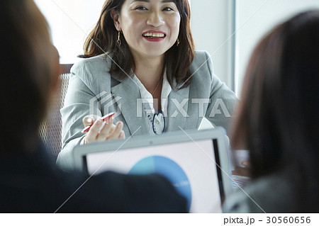 A portrait of a businesswoman smiling with other people. A portrait of a businesswoman smiling with other people. 30560656