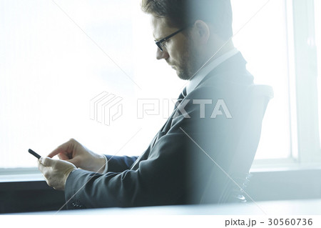a portrait of a man looking at his phone 30560736