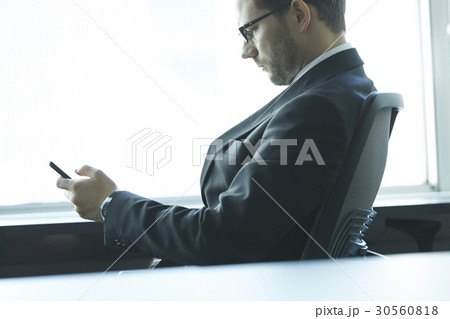 a portrait of a businessman looking at his phone 30560818