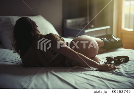 Beautiful naked girl lies on a bed in headphones Beautiful naked girl lies on a bed in headphones 30562749