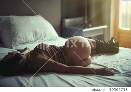 Beautiful naked girl lies on a bed in headphones  30562753