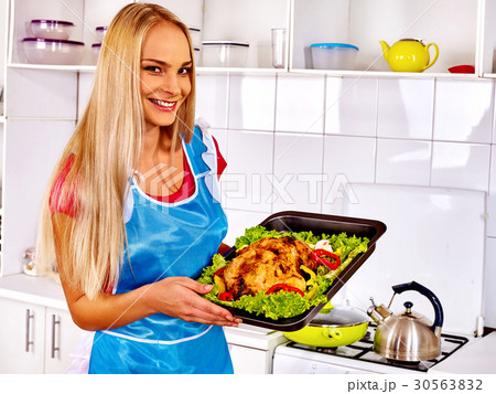 Women in kitchen is cooking roast meat food in 30563832