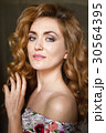 Beautiful young woman with long red curvy hair 30564395