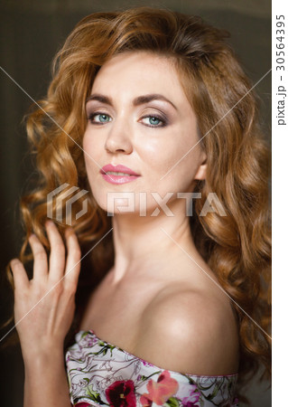 Beautiful young woman with long red curvy hair Beautiful young woman with long red curvy hair 30564395