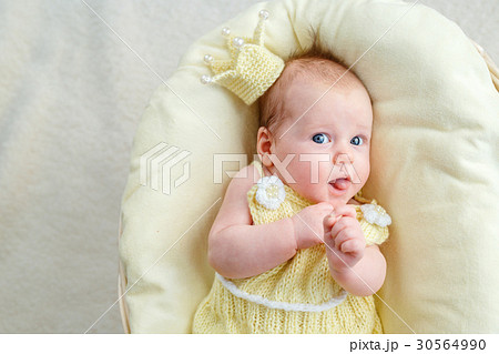 Newborn baby girl lying in a basket with crown and 30564990