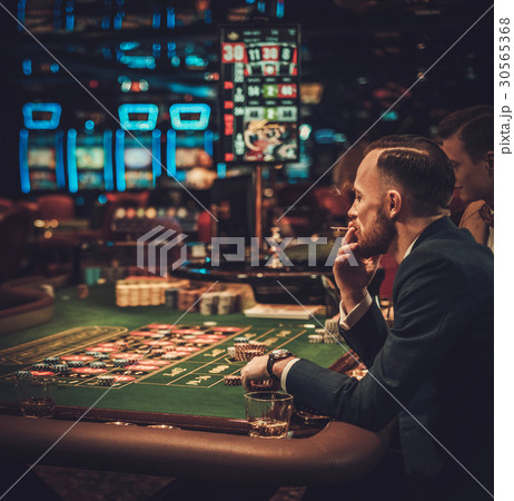 Upper class friends gambling in a casino Upper class friends gambling in a casino 30565368