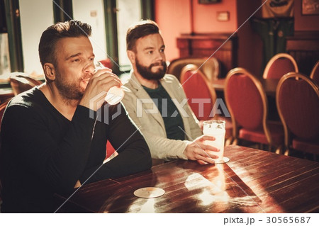 Friends watching TV and drinking draft beer in pub 30565687