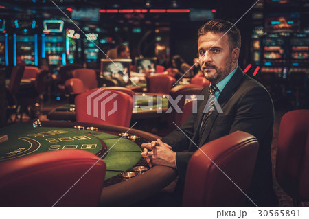 Upper class man behind gambling table in a casino 30565891