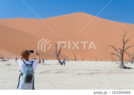 Tourist taking photo at Sossusvlei Tourist taking photo at Sossusvlei 30566966