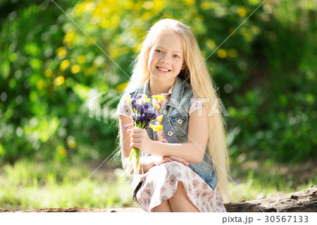 Little blonde girl with bouquet of flowers 30567133