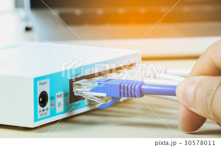man connects Internet cable in the routersele man connects Internet cable in the routersele 30578011