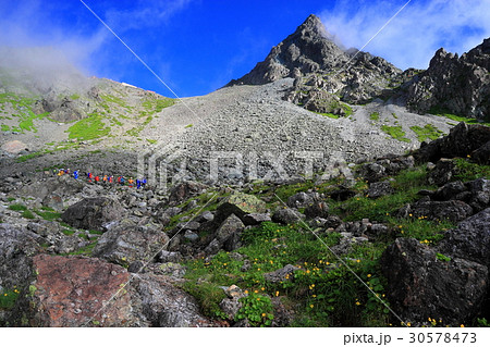 雲湧く槍ヶ岳と槍沢を行く登山者 30578473