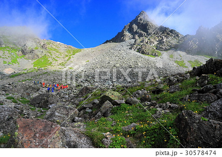 雲湧く槍ヶ岳と槍沢を行く登山者 30578474