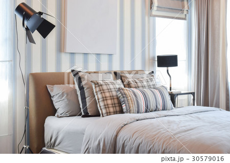 stylish bedroom with striped pillows on bed 30579016