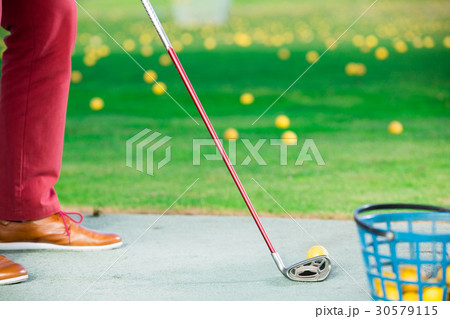 Golfer ready to strike the ball with a club Golfer ready to strike the ball with a club 30579115