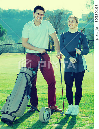 Male and female golfers ready for team play at golf course Male and female golfers ready for team play at golf course 30580198