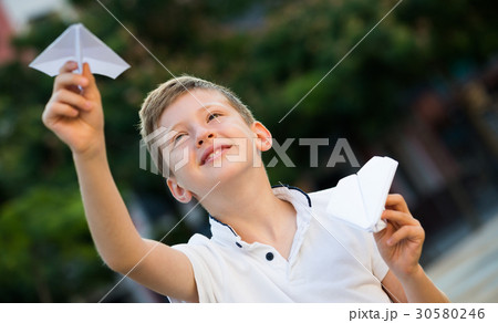 boy playing with paper airplane 30580246