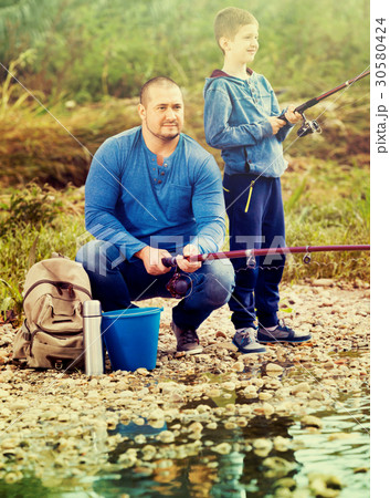 Portrait of father and son fishing with rods 30580424