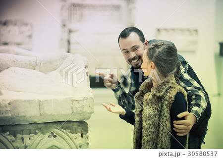 happy father and daughter regarding classical bas-reliefs in museum 30580537
