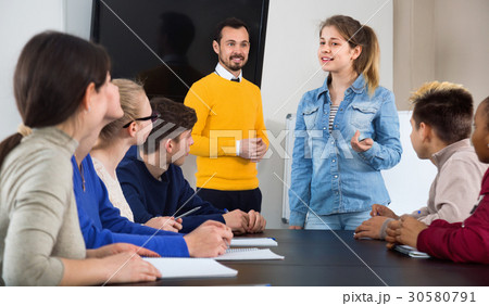 Female student answering teacher’s question at writing board 30580791