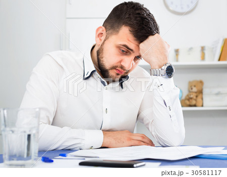 Young male worker having problem in project in office Young male worker having problem in project in office 30581117