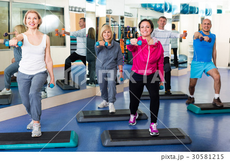 Group training in gym with dumbbells. Group training in gym with dumbbells. 30581215