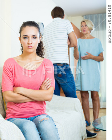 Upset girl watching her husband and senior mother fighting Upset girl watching her husband and senior mother fighting 30581410