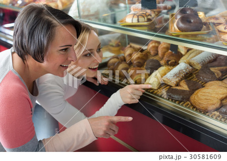 Girl and woman gladly choosing pastry Girl and woman gladly choosing pastry 30581609