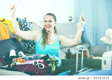 Happy girl traveler packing suitcase for holiday 30581610