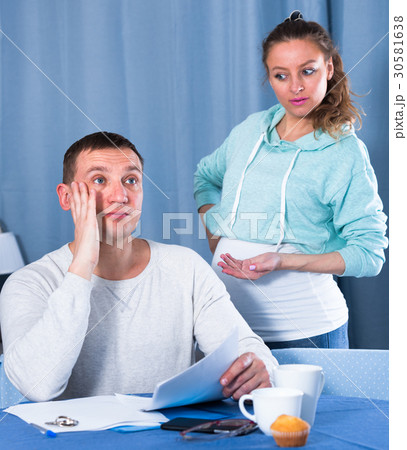 Husband and pregnant wife arguing at home 30581638