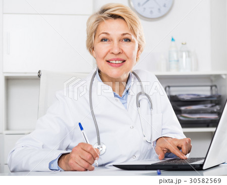 Doctor in gown waiting for patient Doctor in gown waiting for patient 30582569