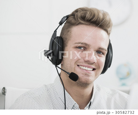 Male assistant with headphones indoors Male assistant with headphones indoors 30582732