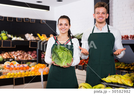Two young assistants displaying vegetables 30582982