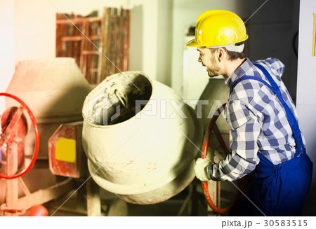 Positive male worker using concrete mixer 30583515