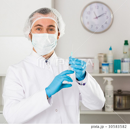 Male nurse preparing injection 30583582