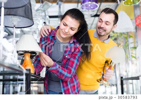 Girl and man in shop of home appliances are choosing night lamp Girl and man in shop of home appliances are choosing night lamp 30583793