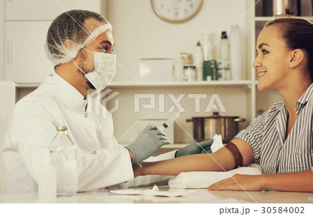 Male nurse injecting female patient Male nurse injecting female patient 30584002